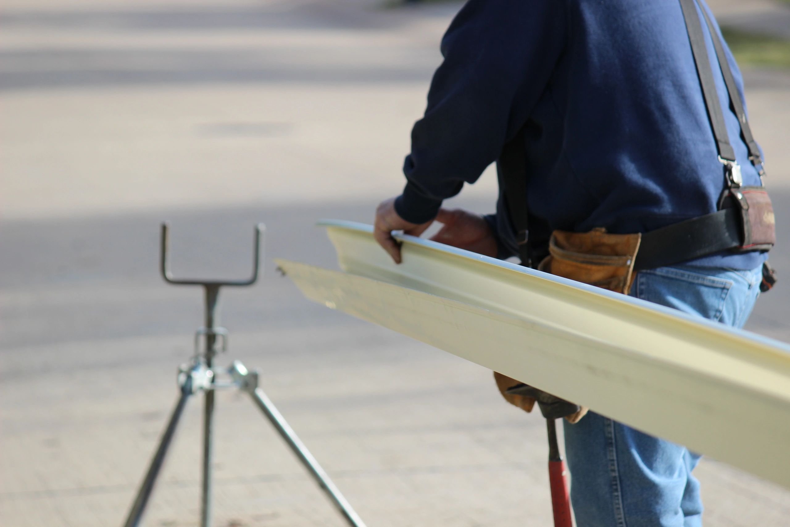 A man holding metal bars while standing on the street.