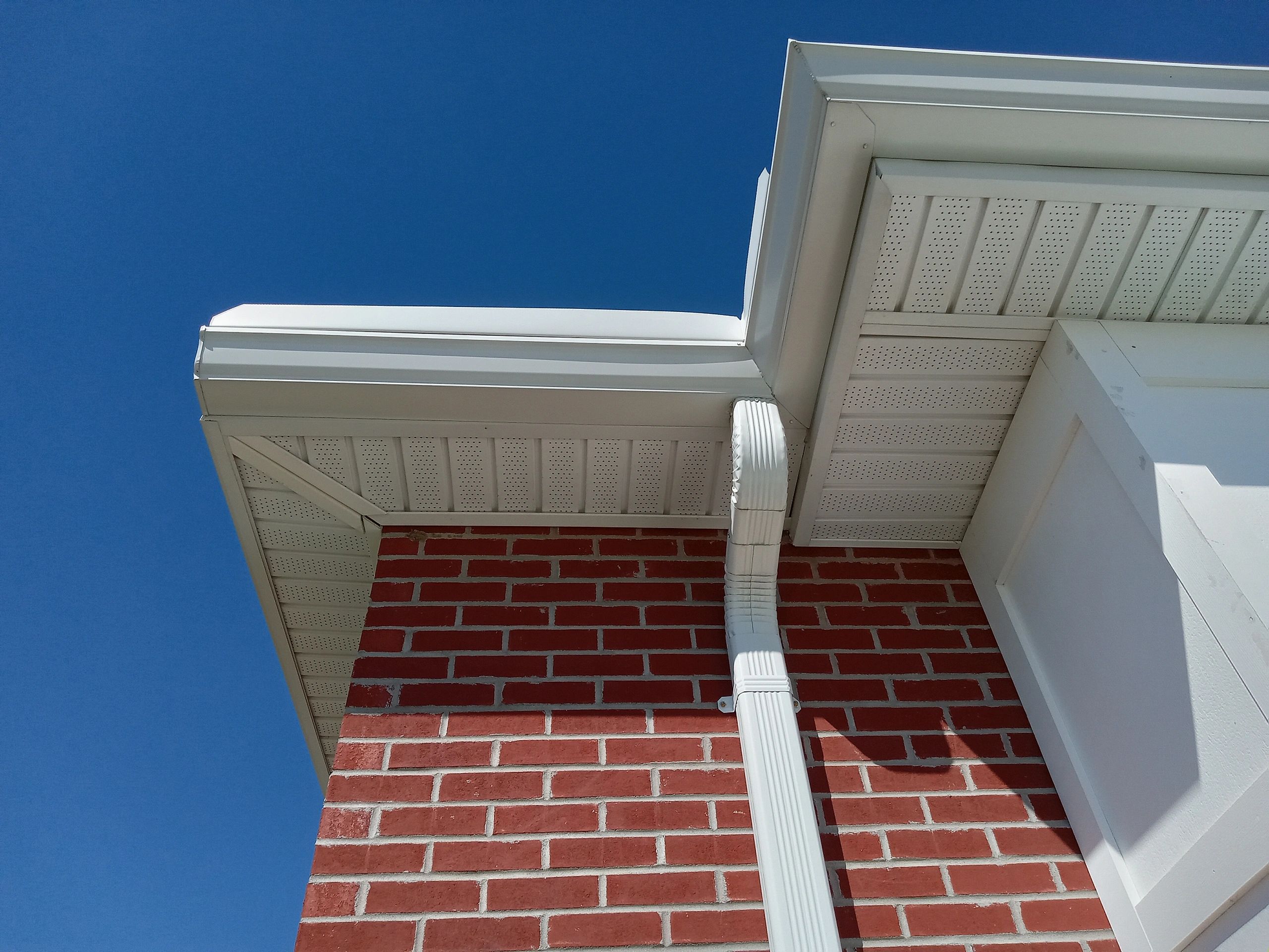 A brick building with white trim and blue sky.