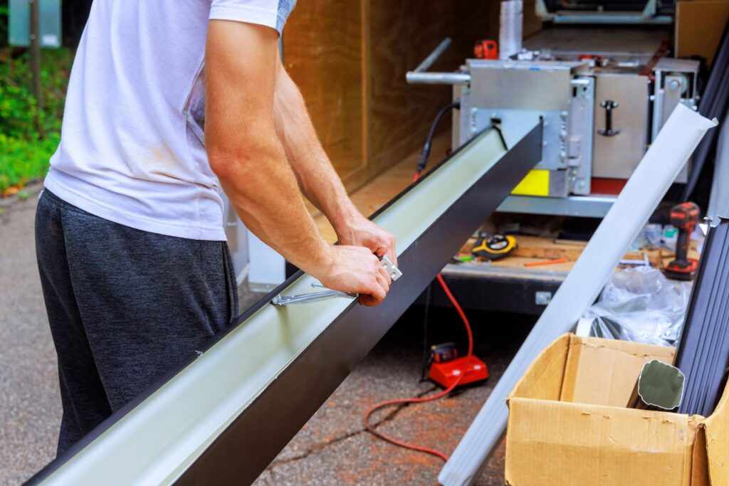 A man is holding the edge of a piece of wood.
